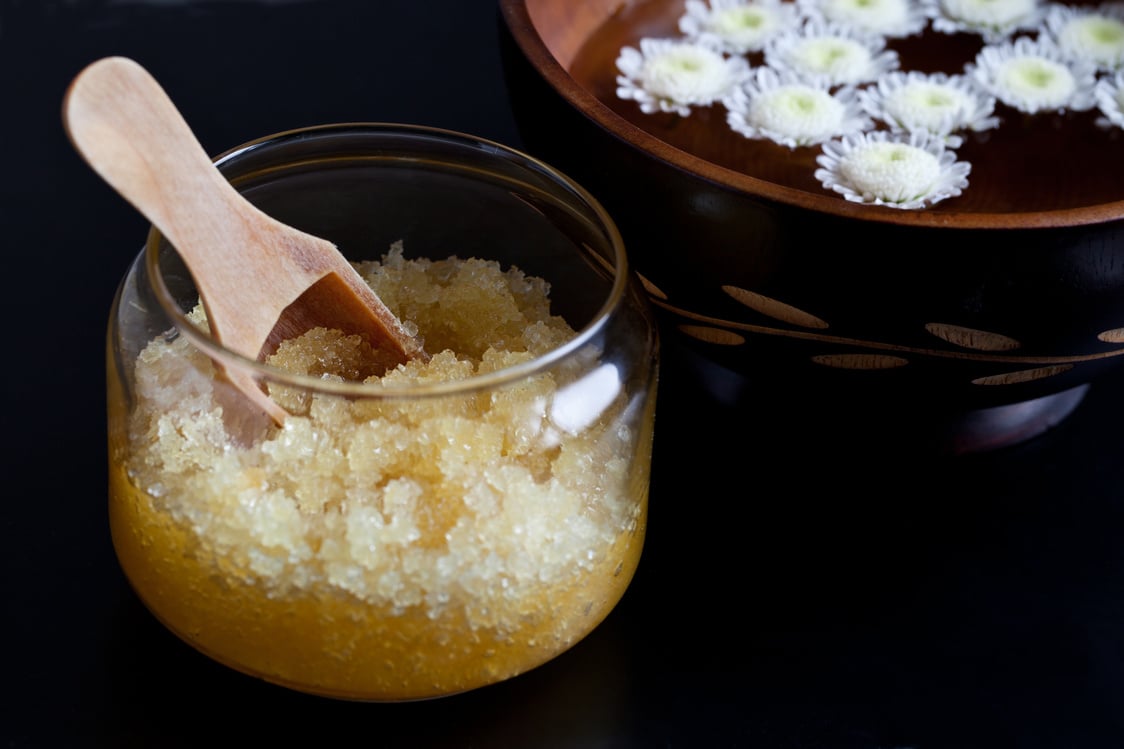 Body scrub and bowl with flowers